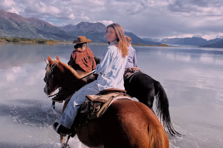 a person riding a horse in a body of water